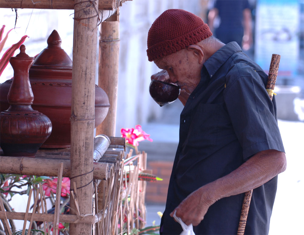 Pete Garwood - Passer-by takes a drink outside wat